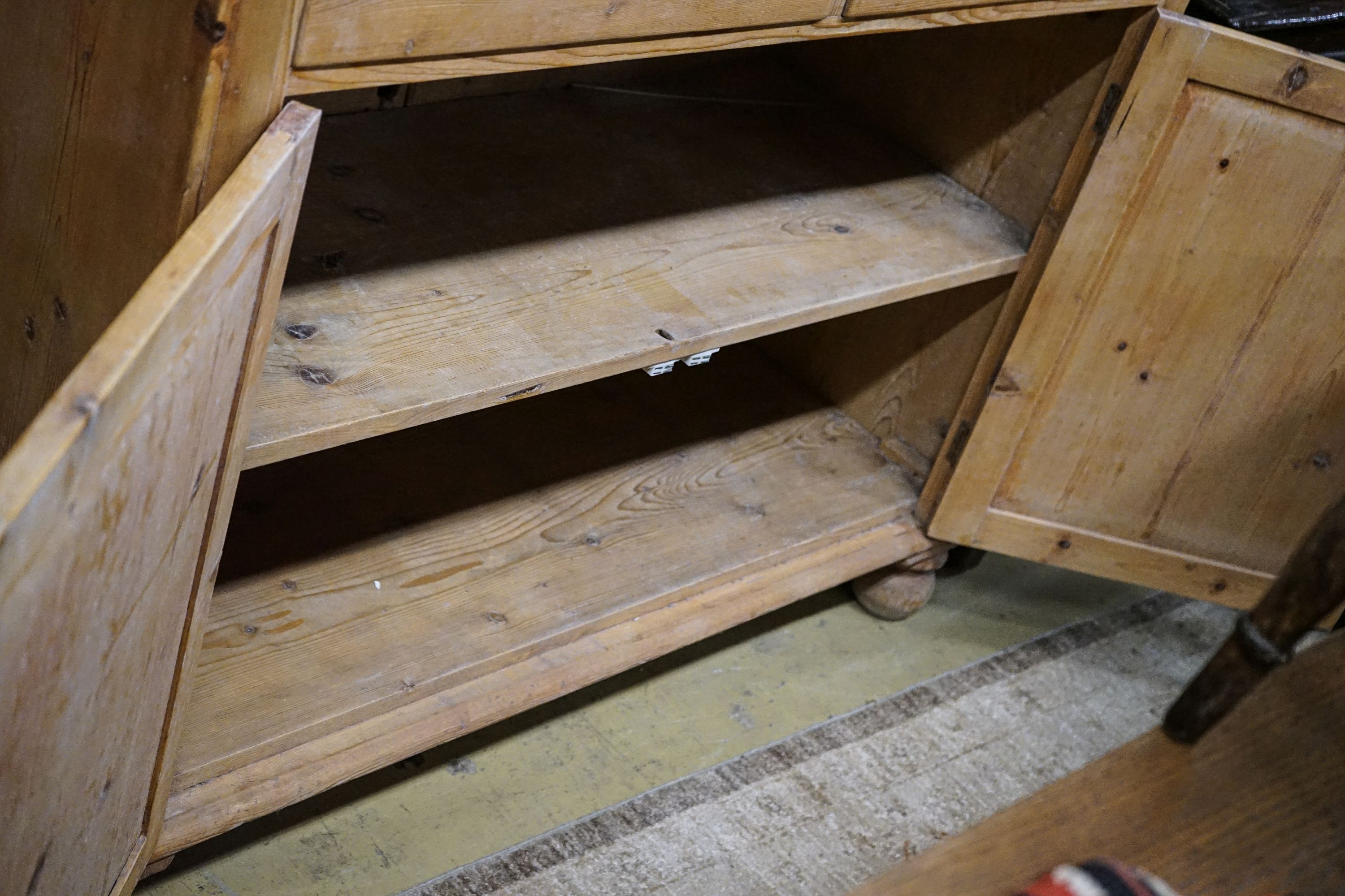 An early Victorian pine chiffonier, fitted two drawers and panelled doors on turned feet, width 121cm, depth 50cm, height 142cm